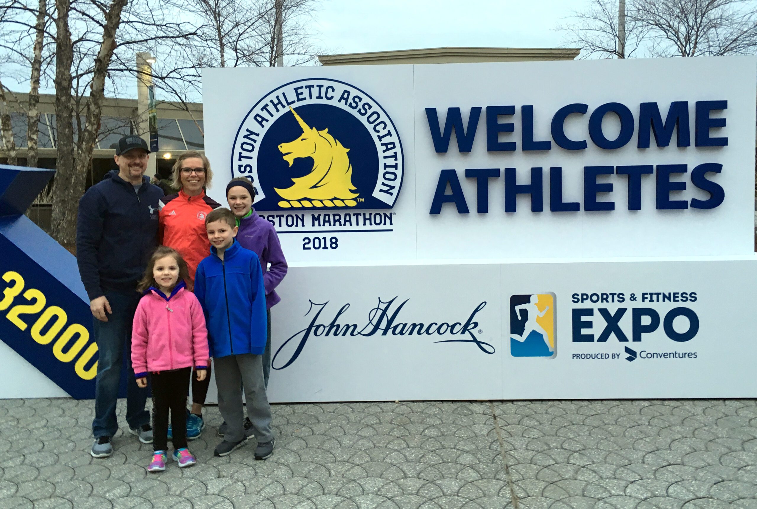 Alison Jones and family pictured at the Welcome Athletes sign in Boston.